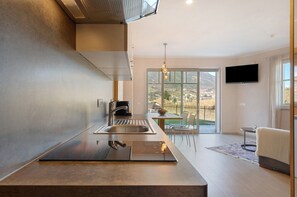 Una cucina moderna con forno integrato, macchina del caffè e un'ampia finestra che si affaccia sull'esterno.