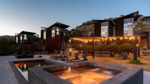 A modern outdoor pool area with lounge chairs and a heated pool.