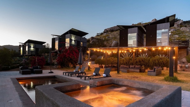 A modern outdoor pool area with lounge chairs and a heated pool.