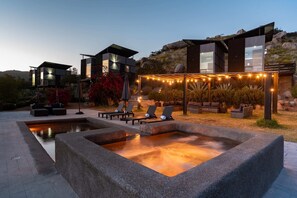 A modern outdoor pool area with lounge chairs and a heated pool. - Atika Retreat - Vinyard Villa (Valle de Guadalupe)