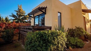 A modern house with a wooden deck, large windows, and a well-maintained garden.