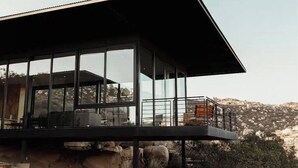 Un bâtiment moderne doté de grandes fenêtres en verre et d’un balcon.