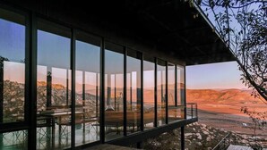 Un edificio moderno con amplios ventanales que ofrecen vistas panorámicas de un paisaje desértico.