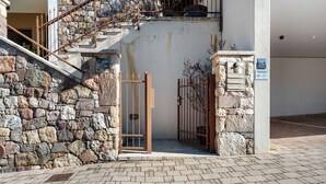 A stone wall, a metal gate, and a staircase leading to a building entrance. - Apartment 'Landhaus Antonius Loft Suite Vitus' with Mountain View, Wi-Fi and Air Conditioning (St. Michael Eppan)