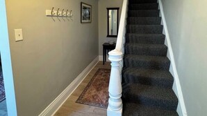 A staircase with a white balustrade leading to a landing. - Spacious & Renovated Buffalo Home in 5 Points- Parking, AC, Wifi, and more (Buffalo)