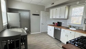 A modern kitchen with white cabinets, a wooden countertop, and a built-in stove. - Spacious & Renovated Buffalo Home in 5 Points- Parking, AC, Wifi, and more (Buffalo)