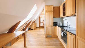 A modern kitchen with wooden cabinets, a black countertop, and a built-in oven.