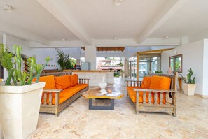 A spacious indoor area with a wooden sofa set, a coffee table, and potted plants. - Coastal Luxury 2-Bed w Pool Access in Bayahibe (Bayahíbe)
