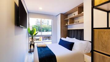 Escritorio, tabla de planchar con plancha y ropa de cama