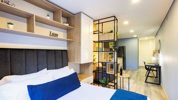 Escritorio, tabla de planchar con plancha y ropa de cama