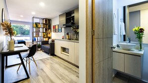 A modern kitchen with a dining area, a built-in bookshelf, and a large window providing natural light. - Comfortable Loft in Zona T w/ Fast Wi-fi (BOGOTA)