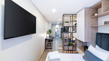 Escritorio, tabla de planchar con plancha y ropa de cama