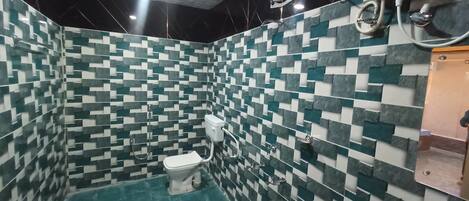 A bathroom with a checkered tile pattern, a toilet, a bidet, and a shower area.