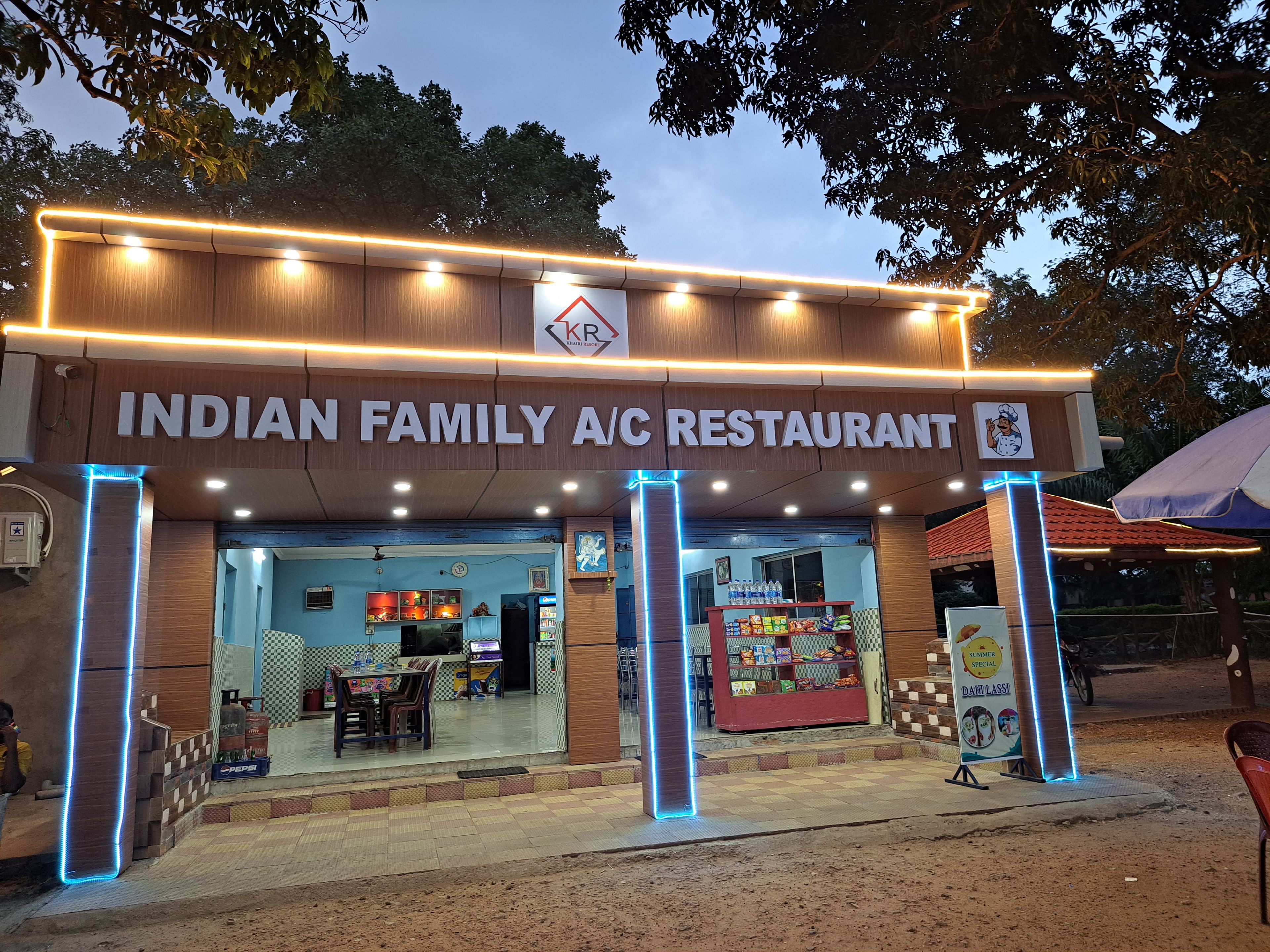 Restaurante para familia, con aire acondicionado, letrero, mesas al aire libre y exhibición de agua embotellada.