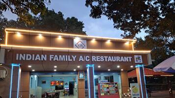 Restaurante para familia, con aire acondicionado, letrero, mesas al aire libre y exhibición de agua embotellada.