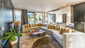A modern living room with a sectional sofa, a coffee table, and a large window providing a view of the outdoors.