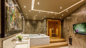A modern bathroom with a large bathtub, a separate shower area, and a vanity with a mirror and sink.