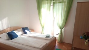 A double bed with white and blue pillows, a green curtain, and a wooden wardrobe. - Room in Lopar with Balcony, WIFI (4620-94) (Lopar)