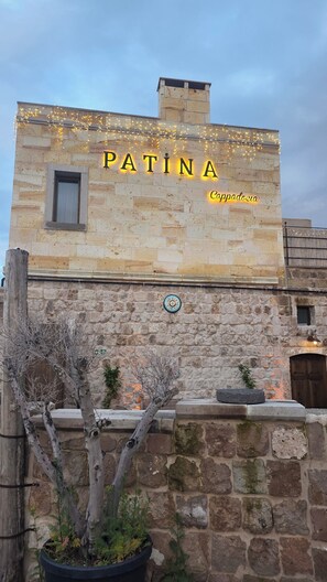 A stone building with the name 'PATINA' and 'Cappadocia' illuminated on the facade. - Patina Cappadocia  (Nevsehir)