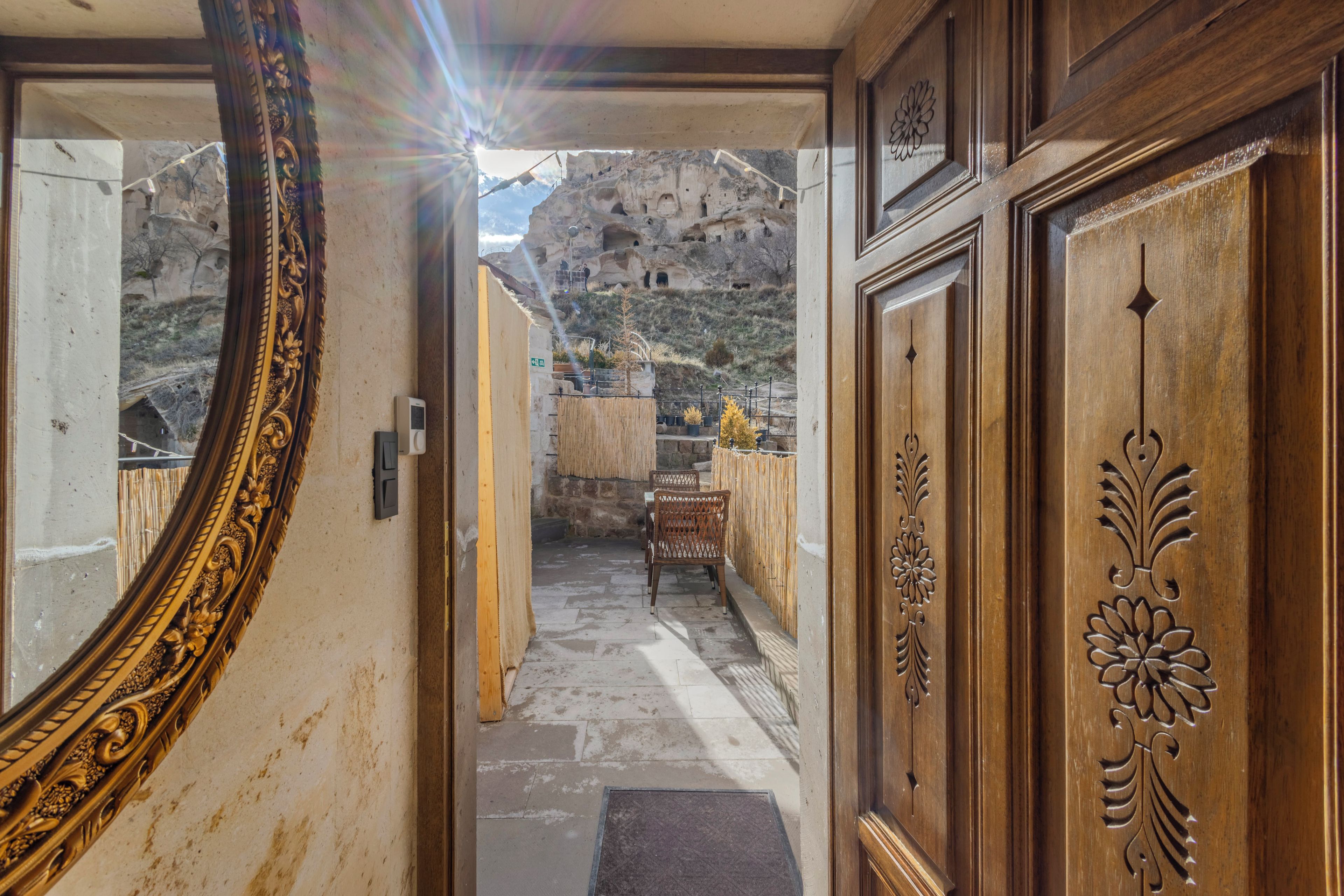 A corridor leading to a balcony with a view of a rocky landscape.