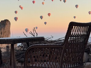 Wicker furniture with a view of hot air balloons in the background. - Patina Cappadocia  (Nevsehir)