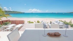 A beachside restaurant with outdoor seating overlooking the ocean. - Luxury Beachfront Enclave Unit 1 (Sandy Ground)