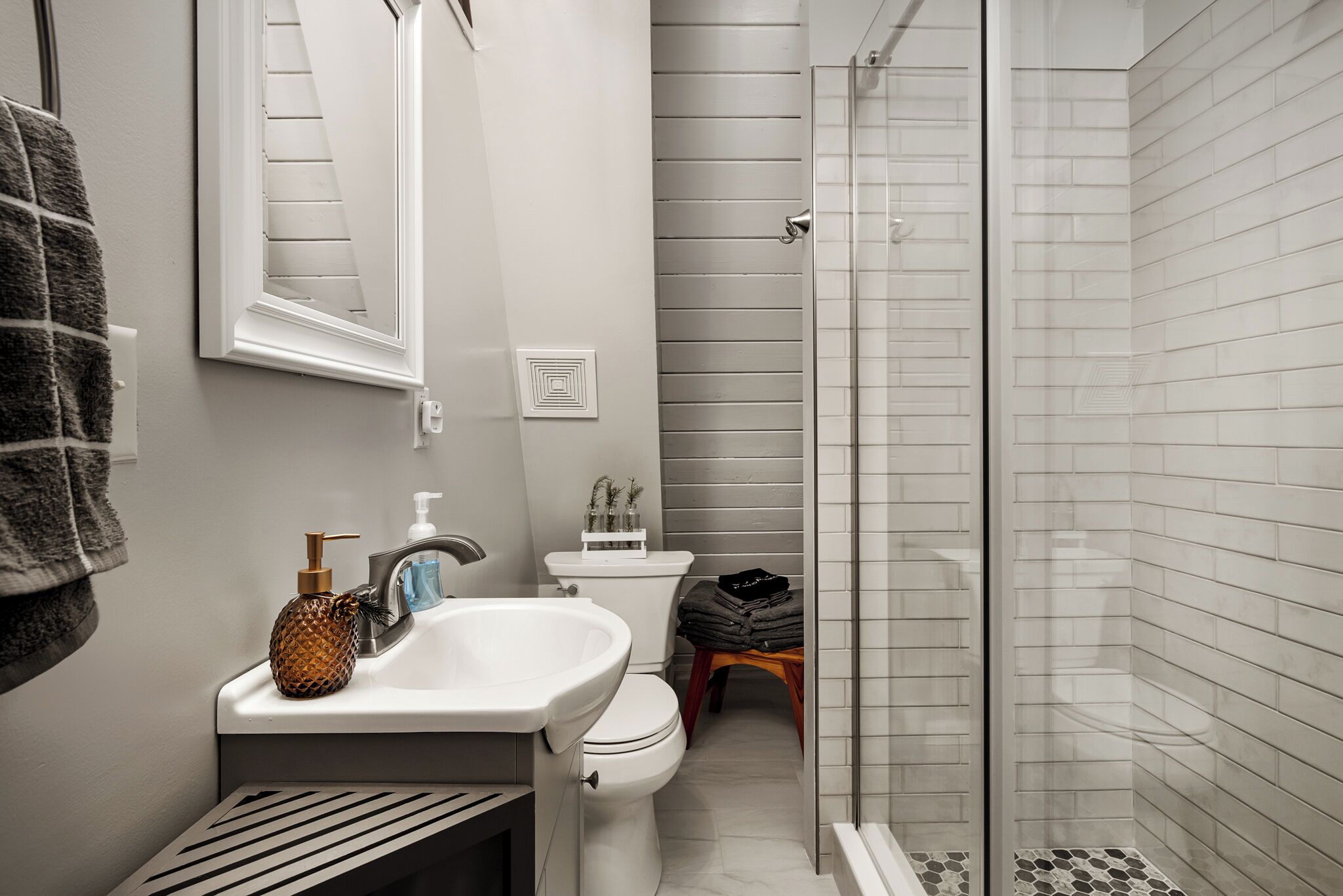 A bathroom with a sink, toilet, and glass shower enclosure.