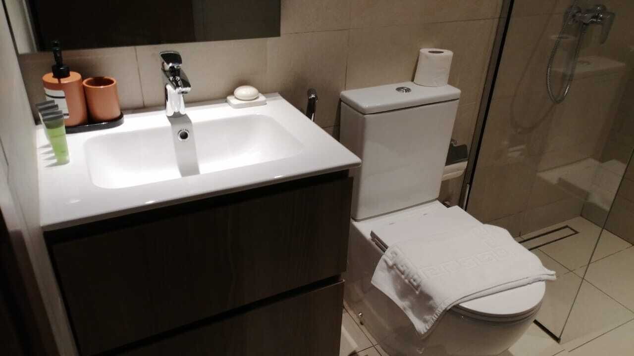 A modern bathroom with a white sink, toilet, and shower.
