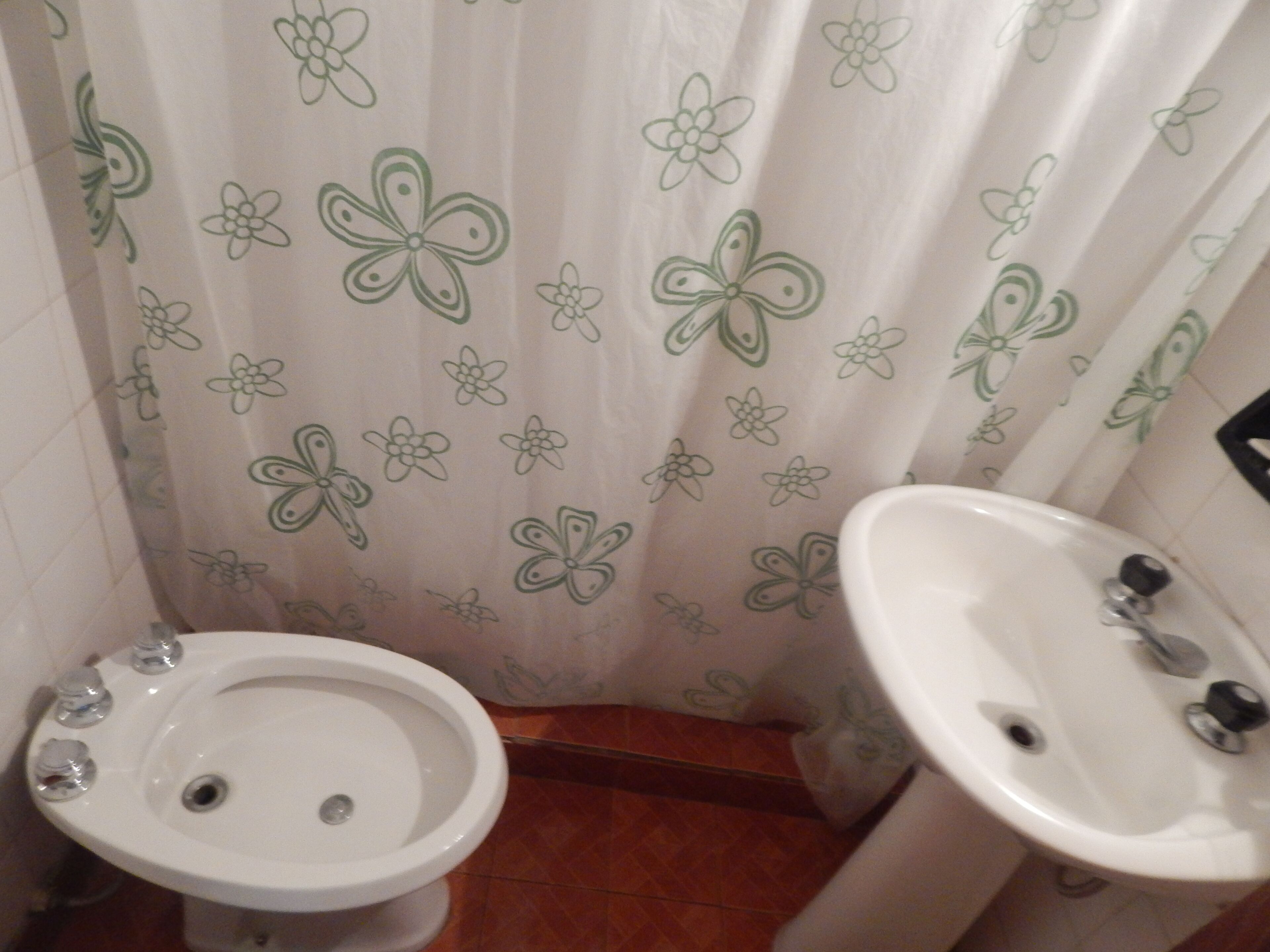 A bathroom with a toilet, bidet, and sink.