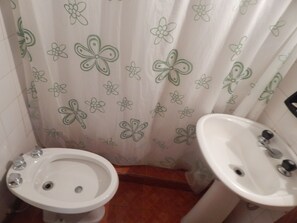 Un baño con inodoro, bidé y lavabo.