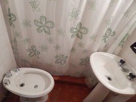 A bathroom with a toilet, bidet, and sink.
