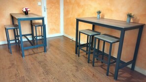 A room with two tables, one with a chair and the other with two chairs.