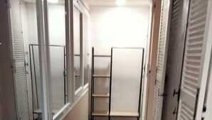 A corridor with a tiled floor, a glass door, and a metal shelf unit. - Holiday Home 'Au Nid Douillet' with Shared Terrace, Shared Garden and Wi-Fi (Bourges)