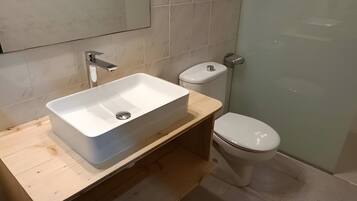A bathroom with a white sink, toilet, and shower.