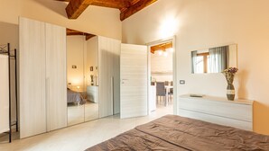A bedroom with a bed, a wardrobe, a mirror, and a dresser. - Holiday Home 'Numero 1' with Shared Garden (Firenzuola)