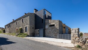 Un bâtiment en pierre avec une extension moderne, une enseigne indiquant « PALACIO ORTIGOSA » et une entrée fermée par un portail.