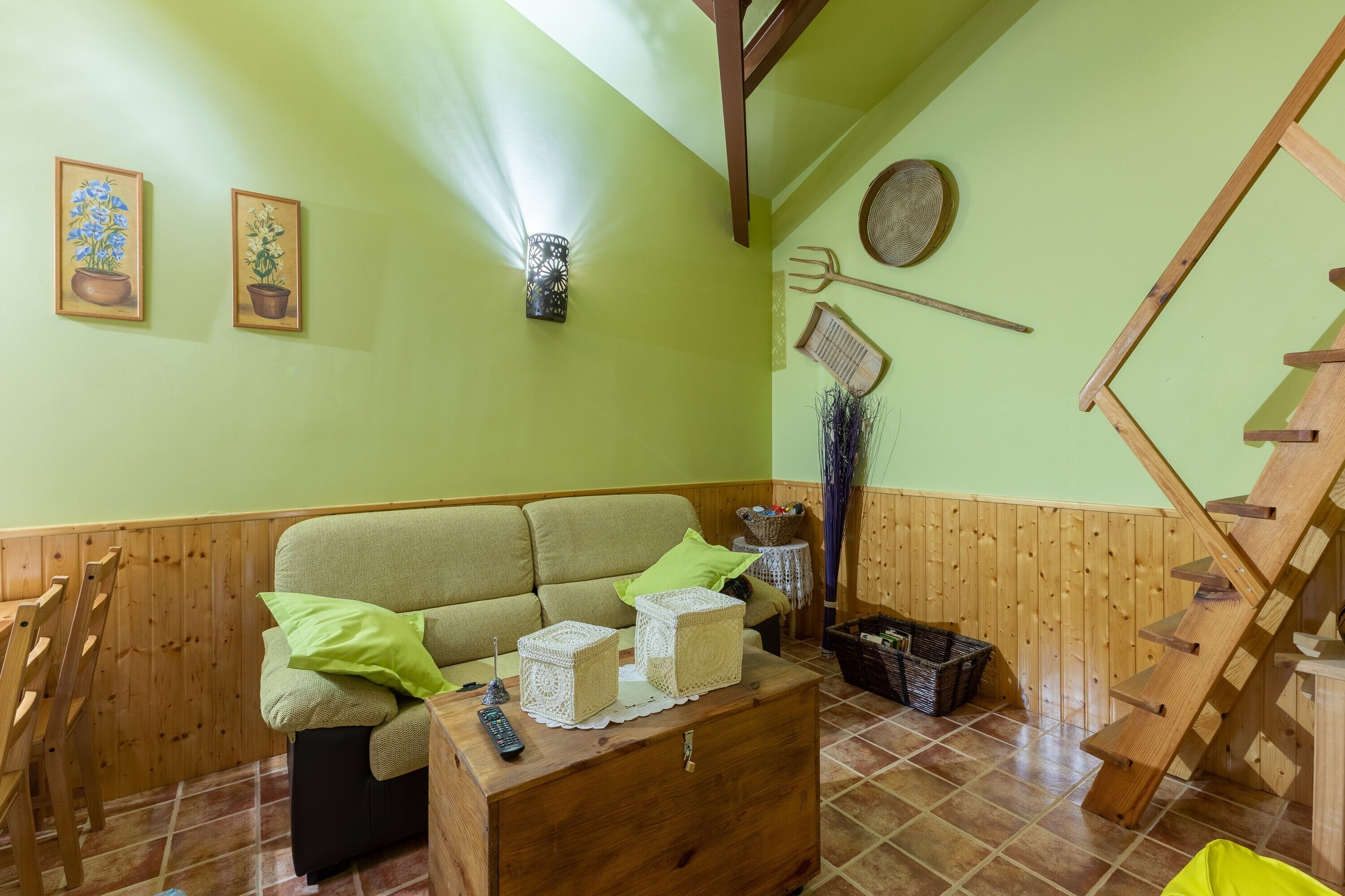 Una sala acogedora con sofá, mesa de centro de madera y una escalera.