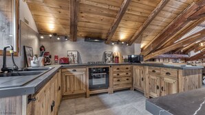 A kitchen with wooden cabinets, a built-in oven, and a microwave. - Magnificent traditional 4 bedroom farmhouse a walk from Chamonix centre (Chamonix)