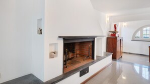 Ein modernes Interieur mit Kamin, Holzschrank und weißer Wand.