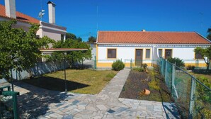 A building with a red-tiled roof, a small garden with a pathway, and a fence. - Cottage 'Casas Da Lagoa - T2 Sul' with Private Garden, Balcony and Wi-Fi (Brescos)