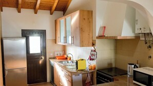 A kitchen with wooden cabinets, a refrigerator, a stove, and a microwave. - Cottage 'Casas Da Lagoa - T2 Sul' with Private Garden, Balcony and Wi-Fi (Brescos)