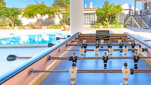 A foosball table with a pool in the background. - Villa 'Beautiful Deluxe 4 Bedroom' with Private Pool, Garden & Wi-Fi (Brescos)