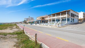 A coastal street with buildings, a red bike lane, and a clear blue sky. - Apartment 'Vistamar Sa Rapita' with Sea View, Wi-Fi and Air Conditioning (Sa Ràpita)