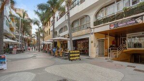 Una calle con terrazas, un bar y una sala de manicura.