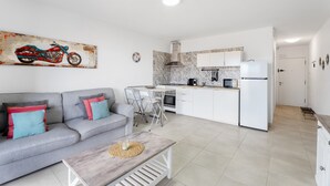 Una cocina moderna con armarios blancos, un microondas y un refrigerador.