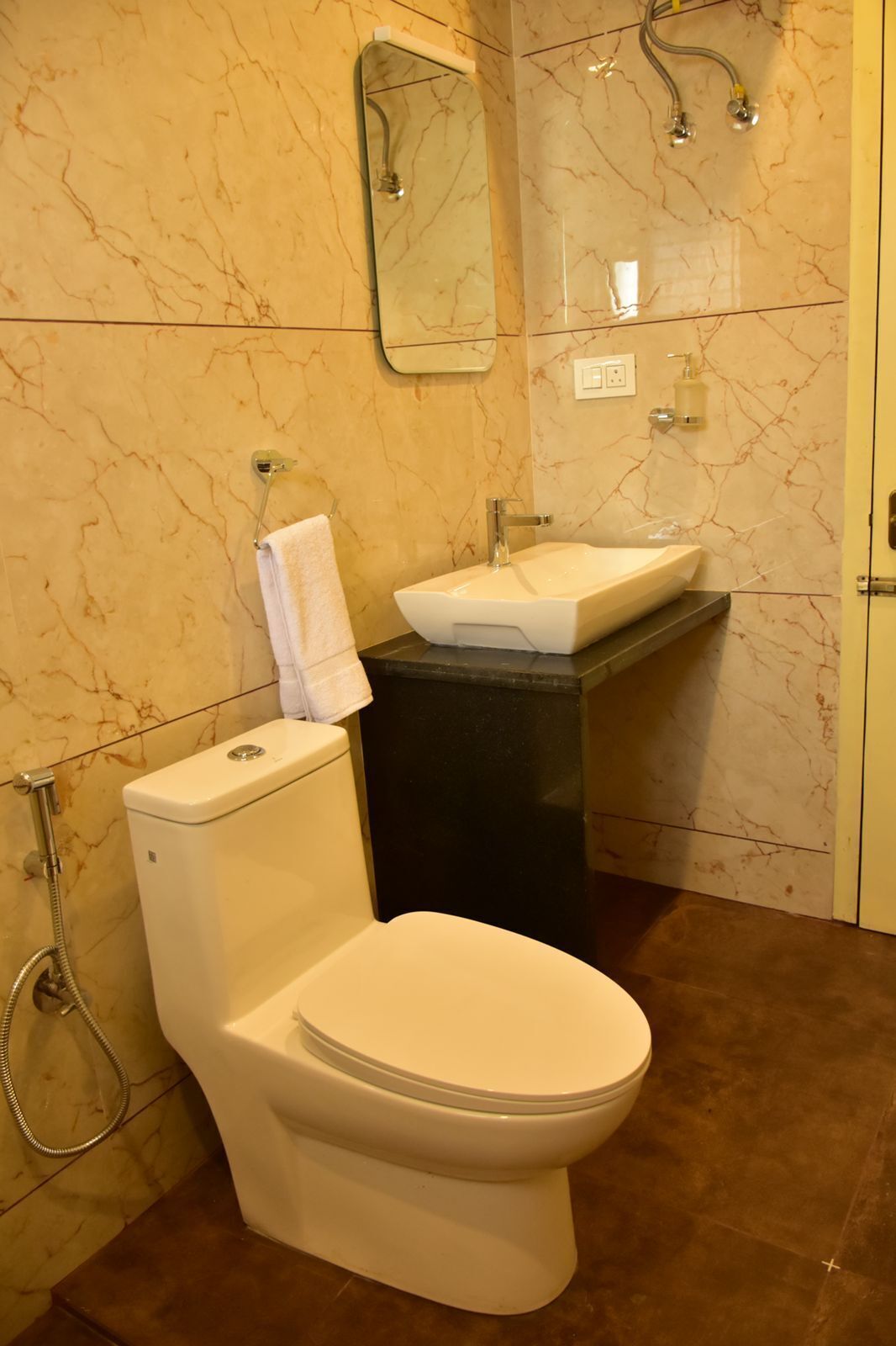 A bathroom with a white toilet, a black sink, and a mirror on the wall.