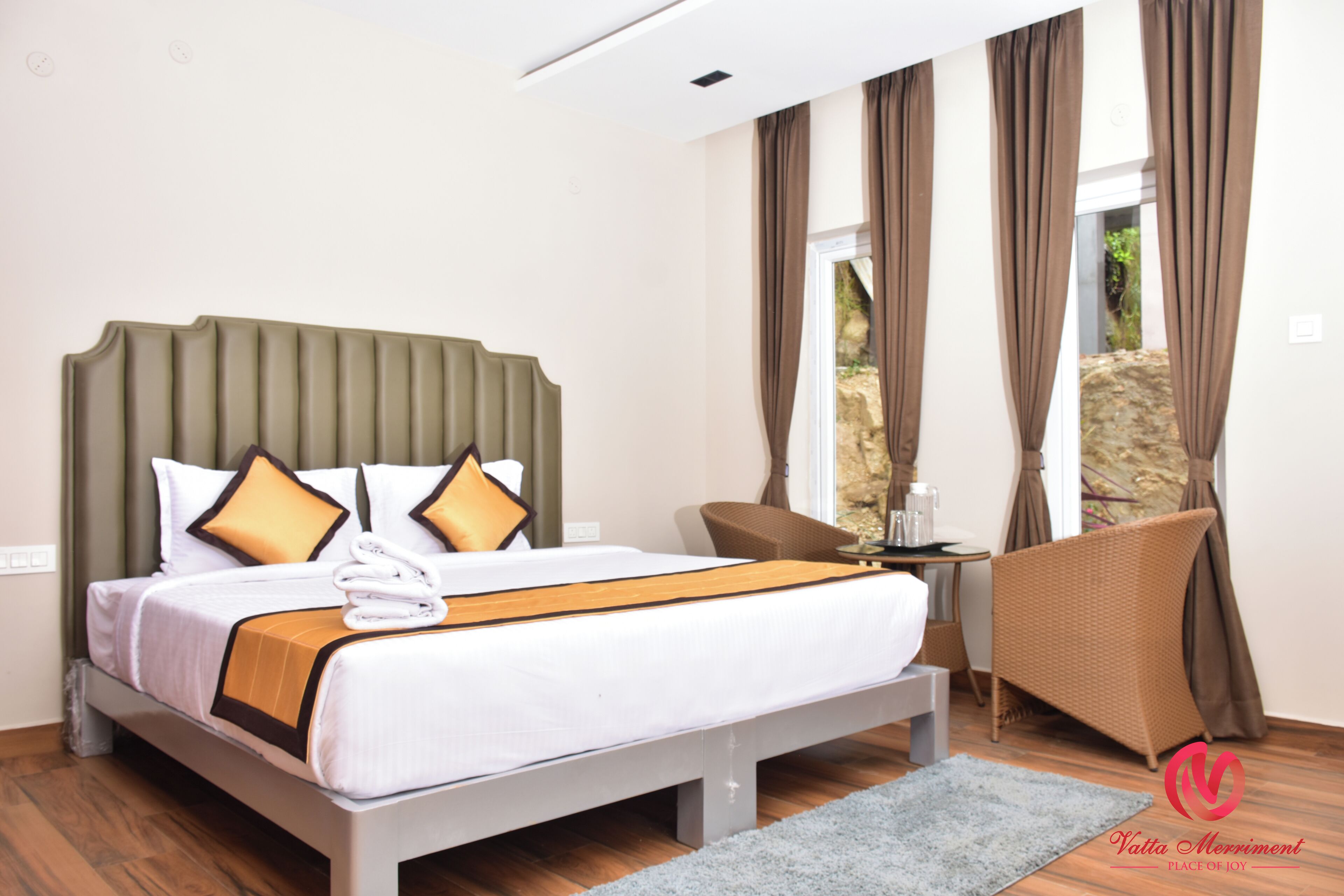 A modern hotel room with a large bed, a seating area, and a view of the outdoors.