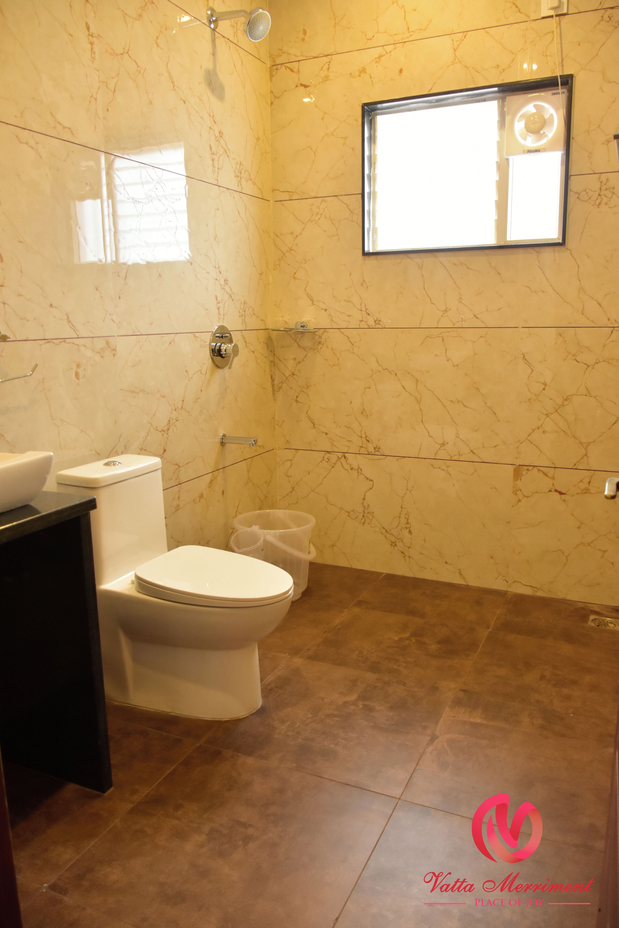 A bathroom with a toilet, bidet, and a mirror with a light fixture.