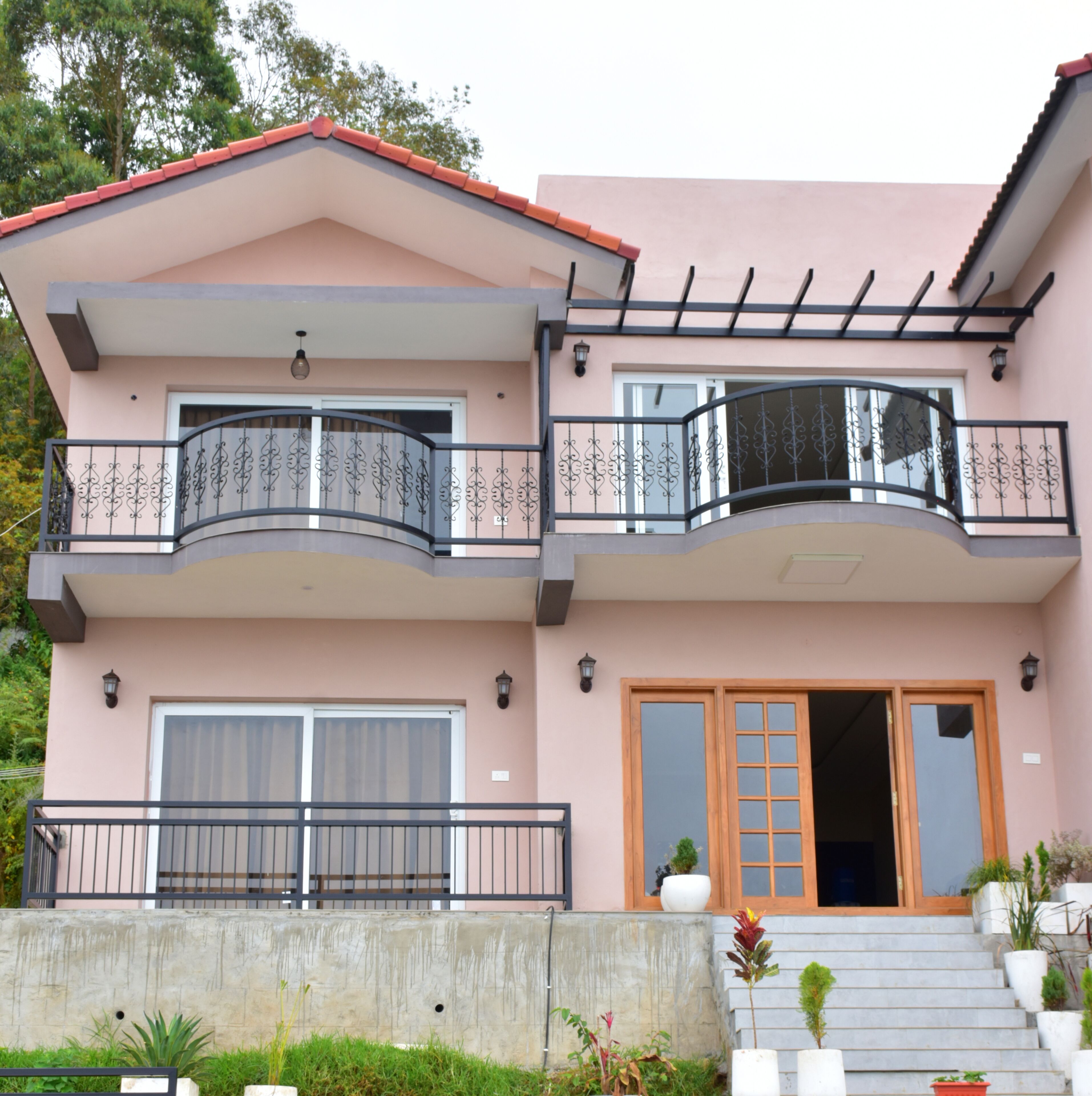 A two-story house with a balcony, a garage, and a staircase leading to the entrance.
