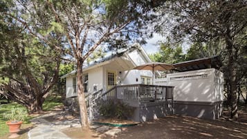 A two-story house with a porch, a covered patio, and a stone pathway leading to the entrance.